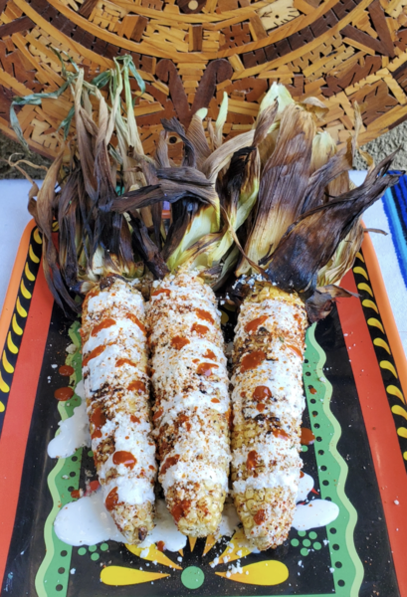 Smoked Mexican Street Corn on Festive Dish Drizzled with Hot Sauce