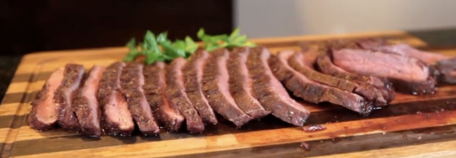 Flank Steak Sliced on Cutting Board with Garnish