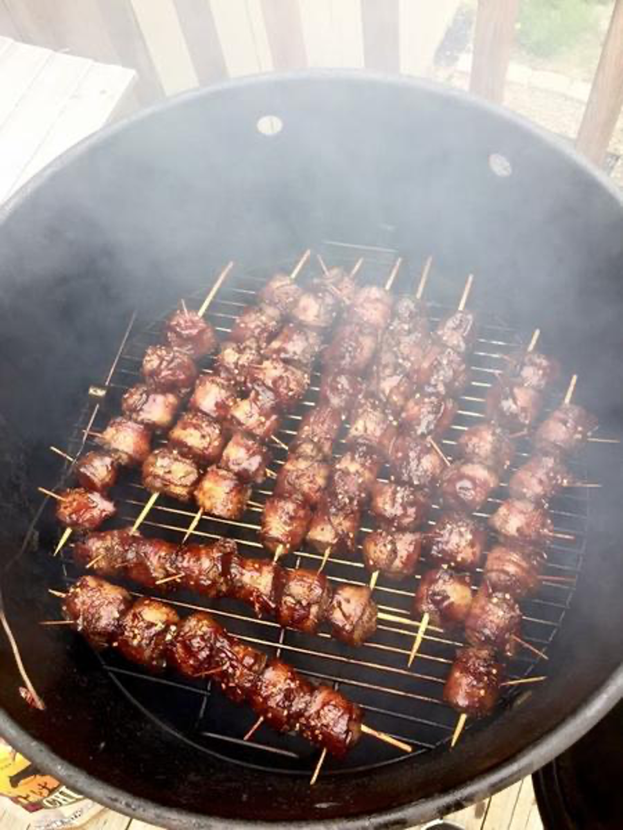 Jalapeño Barbecued Meatballs Wrapped in Bacon Smokin on Skewers in Pit Barrel