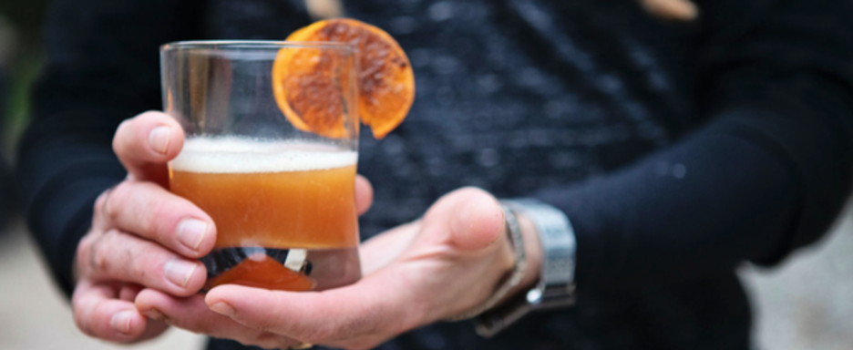 Maple Man Cocktail with Orange Slice in Hand