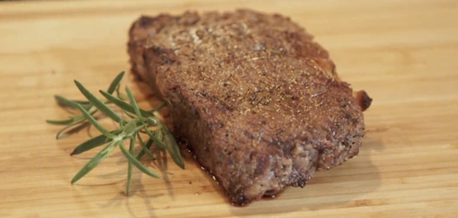 Grilled Steak with Garnish on Cutting Board